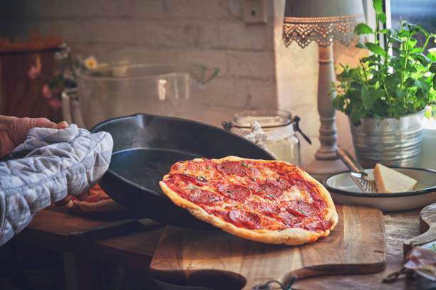 国内キッチンでサラミとパン ピザを準備します。 - tomato sauce domestic kitchen meat cheese ストックフォトと画像