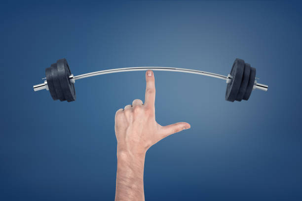 istock Large male hand with a pointed index finger touching a bent weightlifting barbell. 1076815734