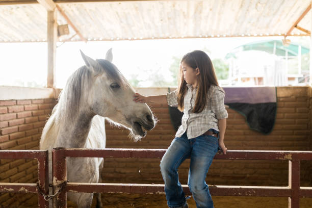 istock Little Rancher Caressing Horse In Stable 1076818678
