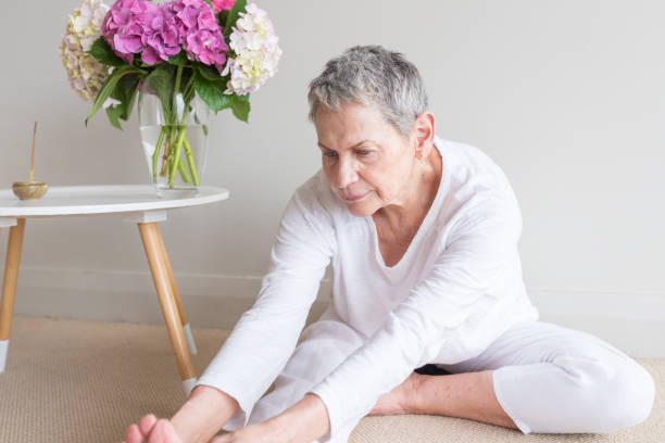istock Older woman seated on floor doing yoga 1076819194