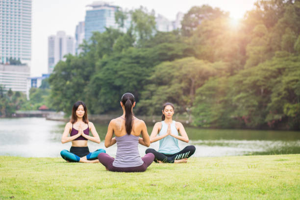 istock Young multi ethnic-women practicing yoga in city park 1076819680
