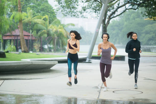 istock Three women concentrating running through park in rain 1076819694