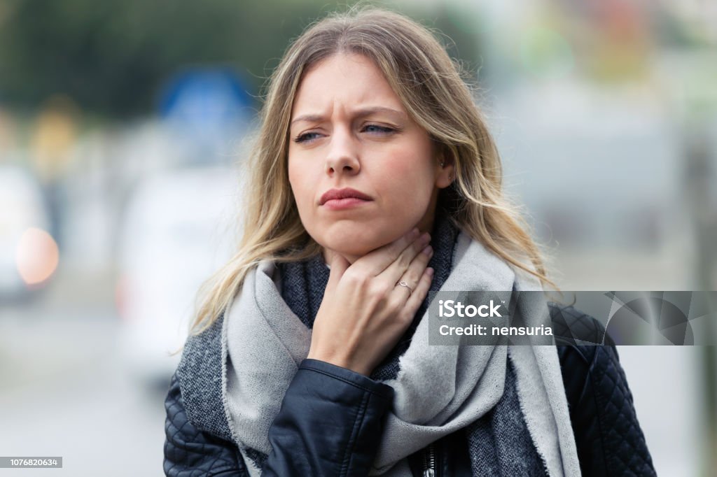 Ziekte jonge vrouw met vreselijke keelpijn lopen naar de straat. - Royalty-free Keel Stockfoto
