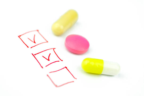 man taking tablet with glass of fresh water. Close up of man holding a glass of water and medication