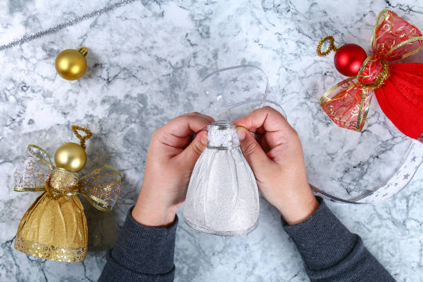 bottiglia di plastica fai da te angel. guida alla foto come realizzare un angelo decorativo da una bottiglia, carta lucida autoadesivo, nastro e una palla di natale con le tue mani. fatto a mano. vista dall'alto. passo dopo passo - humor inspiration angel child foto e immagini stock