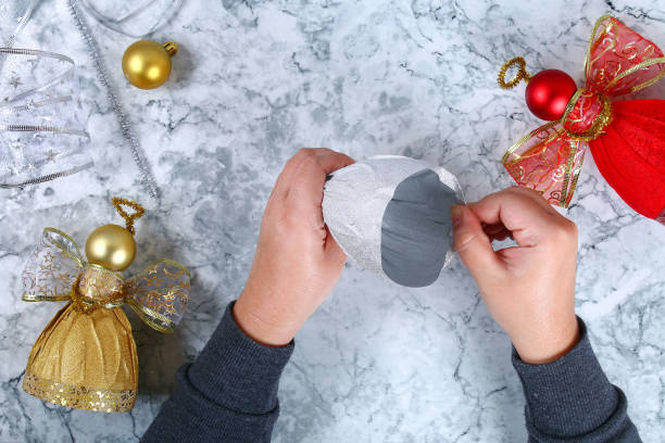 bottiglia di plastica fai da te angel. guida alla foto come realizzare un angelo decorativo da una bottiglia, carta lucida autoadesivo, nastro e una palla di natale con le tue mani. fatto a mano. vista dall'alto. passo dopo passo - humor inspiration angel child foto e immagini stock