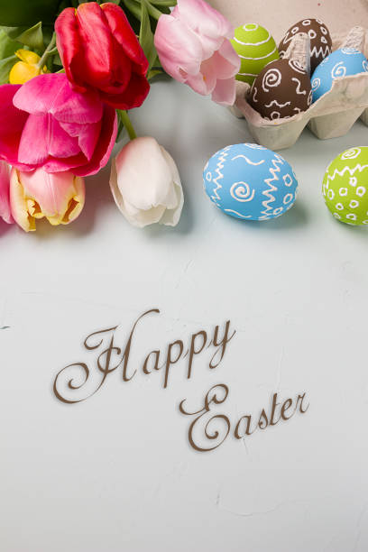 istock Painted easter eggs and branches of spring sakura closeup on a light blue background with space for congratulation 1076828332