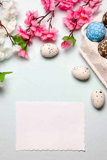istock Painted easter eggs and branches of spring sakura closeup on a light blue background with space for congratulation 1076828400