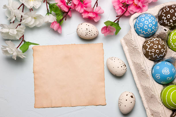 istock Painted easter eggs and branches of spring sakura closeup on a light blue background with space for congratulation 1076828412