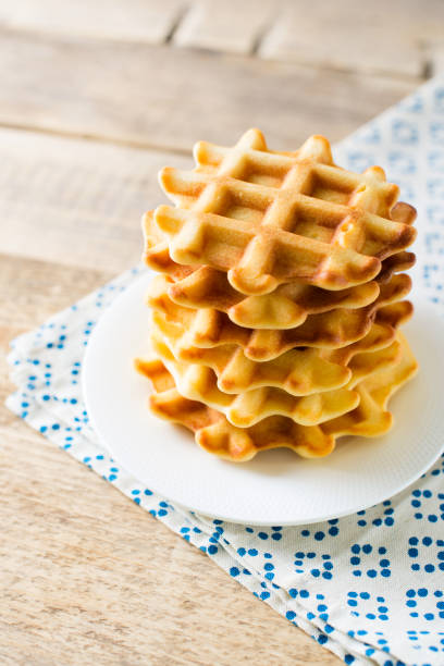 istock Stack of waffles on wooden background 1076832784