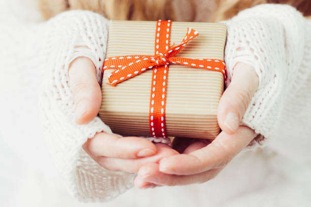 istock Woman's hands hold christmas or new year gift box. 1076844096