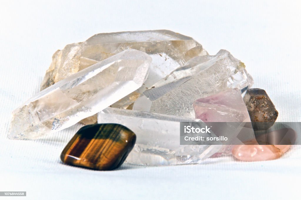 surface level quartz and cats eye on white Eye level close up of  quartz crystals and tiger's eye stone on white. Not isolated Close-up Stock Photo