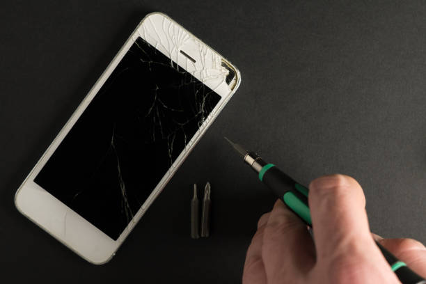 istock Broken white phone with repair tools kit on the dark background with copy space 1076846088