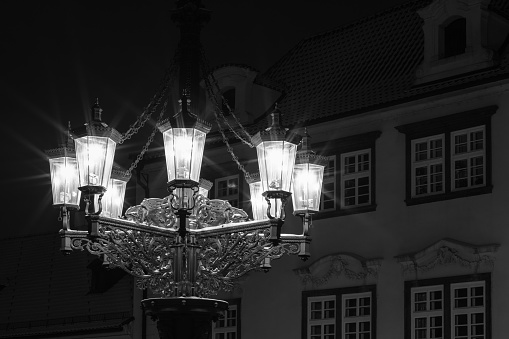 Detail of a historic and ornamental gas candelabrum in a street of Prague. Night image