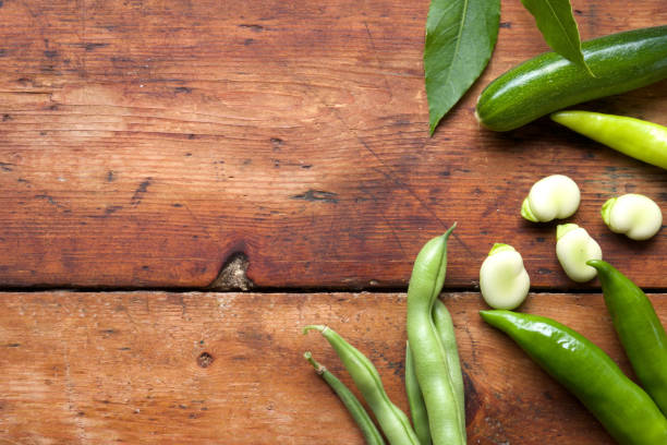 abobrinha zuchinni pimentão verde feijões e favas em uma mesa de madeira rústica - zuchinni - fotografias e filmes do acervo