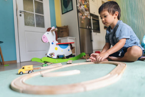 istock Little boy play wiht wooden railway 1076877230