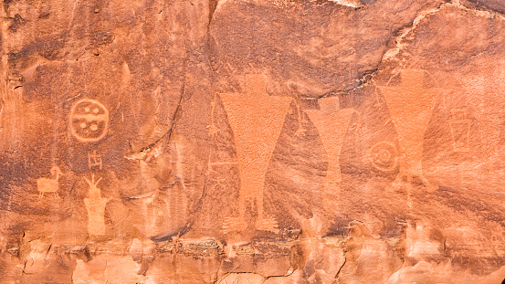Petroglyphs along Kane Creek Road above Kane Springs Canyon with golden Autumn Cottonwood trees near Moab, Utah.