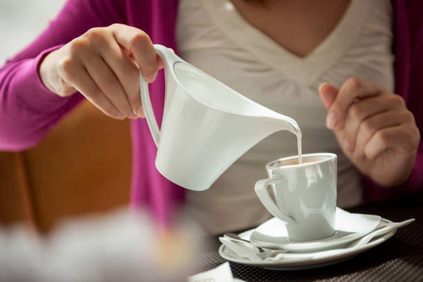 Pouring milk into coffee cup