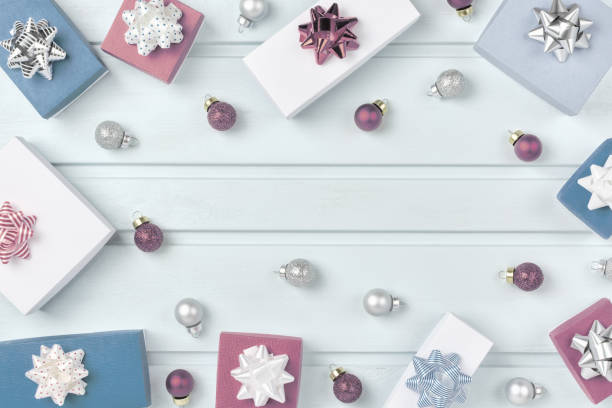 istock Christmas composition with place for text, frame. Gift boxes with bows and small Christmas balls are arranged in a circle on a light blue background. Festive layout with copy space. 1076894298