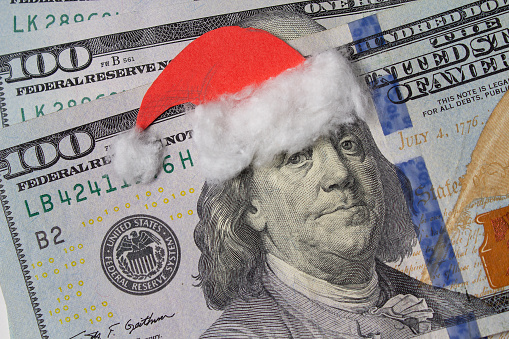 Benjamin Franklin in a Santa Claus hat on a bill. Christmas decorations