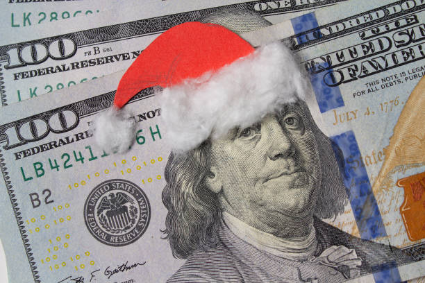 Benjamin Franklin in a Santa Claus hat on a bill. Christmas decorations stock photo