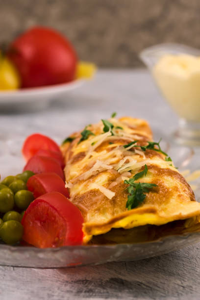 istock Omelet roll. Sliced Tomatoes Marinated green peas. Vertical. Light background. 1076910728