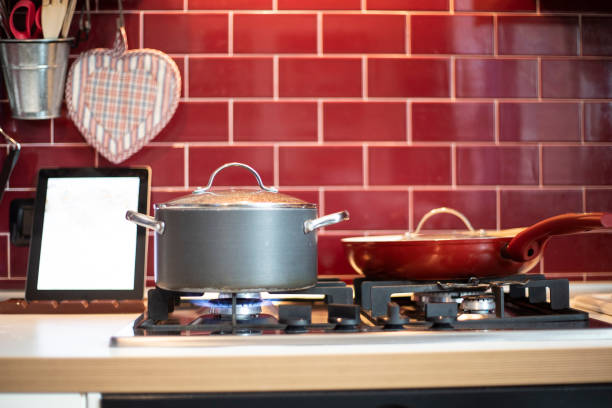 istock pot cooking on gas stove and tablet with blank screen. 1076913850