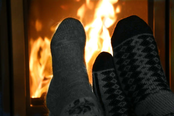 istock Feet in wool socks warming at the fireplace 1076921582