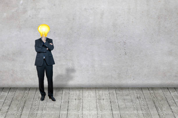 Businessman with bulb instead his head standing in front of the business concept stock photo