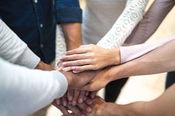 Partners putting their hands on top of each other at workplace