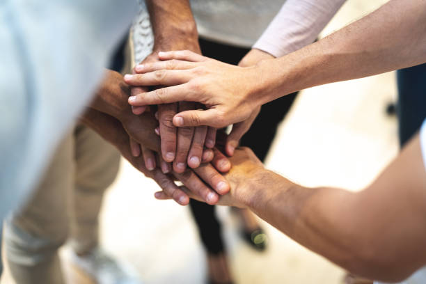 istock Partners putting their hands on top of each other at workplace 1076930350