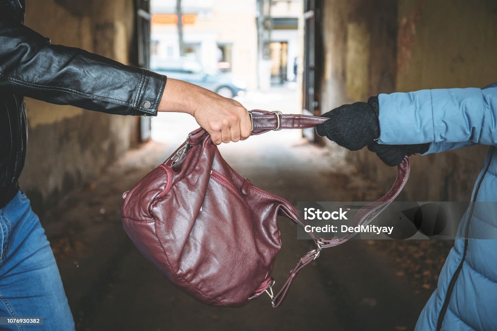 Robber snatches bag from hands of woman, close up. Criminal pickpocket and crimes on city street Robber snatches bag from hands of woman, close up. Criminal pickpocket and crimes on city street concept Purse Stock Photo