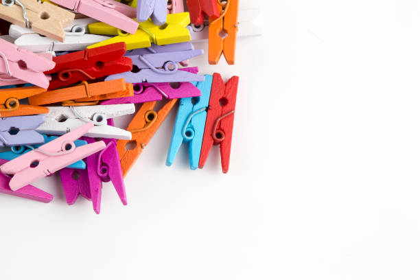 istock Multicoloured wooden clothes pegs on a white background. 1076932910