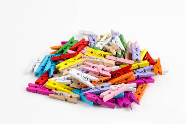 istock Multicoloured wooden clothes pegs on a white background. 1076933012