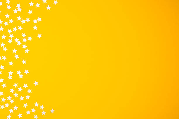 istock Christmas minimal pattern with silver shiny glitter  on yellow pastel  background. Flat lay, top view 1076942034