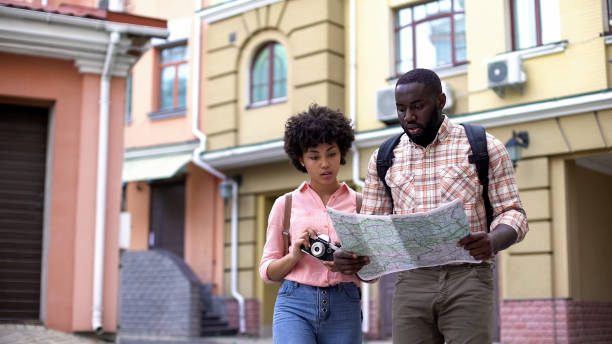 istock Tourists with map and photo camera, choosing direction, travelling vacation 1076945558