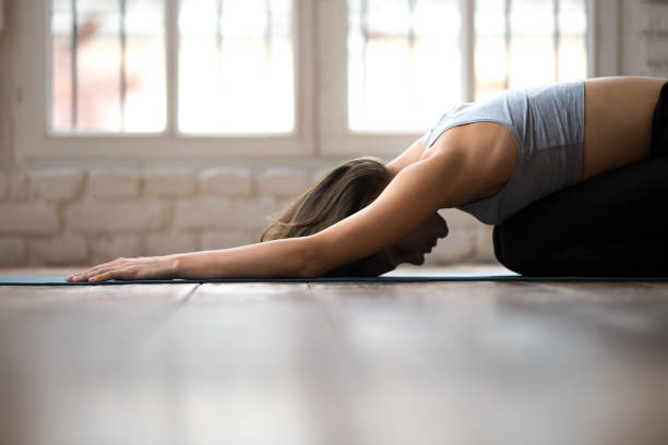 giovane donna sportiva che pratica yoga, fa esercizio bambino, posa balasana - bikram yoga pilates beautiful foto e immagini stock