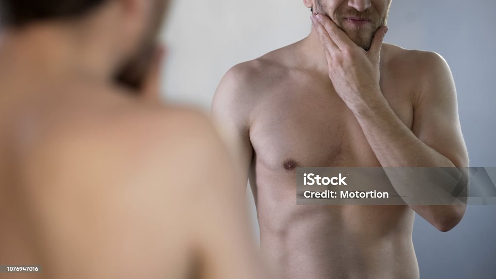 Man looking at his sagging body and beard realizing he caught middle age crisis 30-39 Years Stock Photo