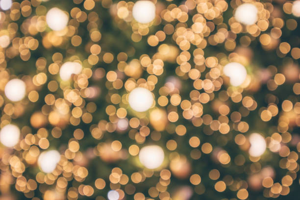 istock Abstract christmas holiday with festive gold bokeh light on tree blurred background 1076949558