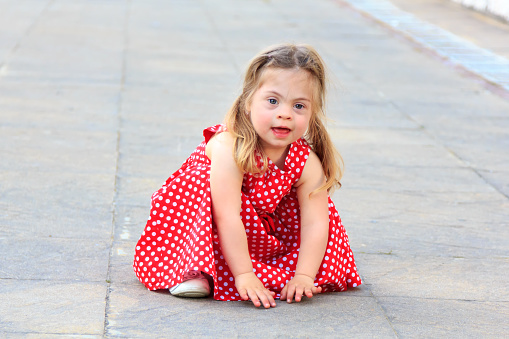 Beautiful little girl with Down syndromе playing