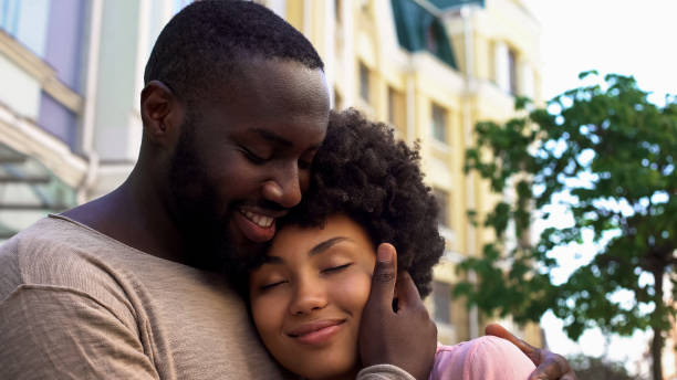 heureuse copine étreignant mâle africaine, épris de rendez-vous romantique de couple, à l’extérieur - couple black american culture kissing photos et images de collection