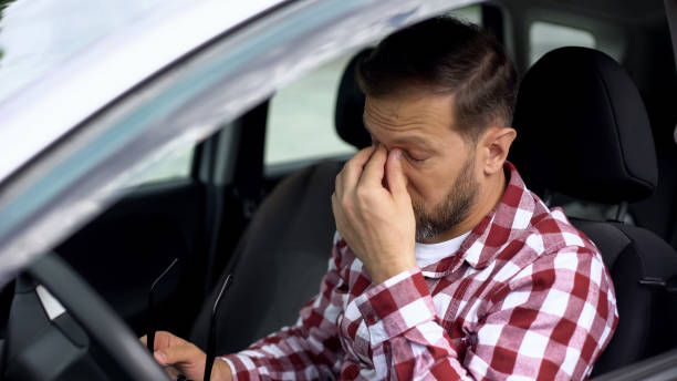 istock Overworked car driver taking eyeglasses off, eyesight disease, health weakness 1076950328