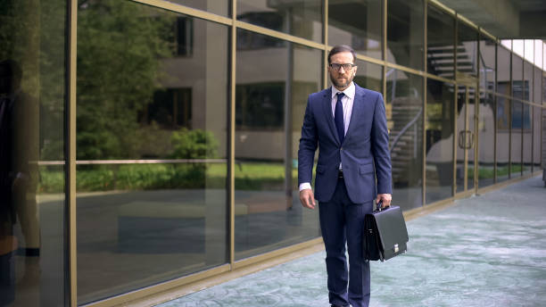 istock Serious business worker going to work, holding briefcase, business center 1076951032