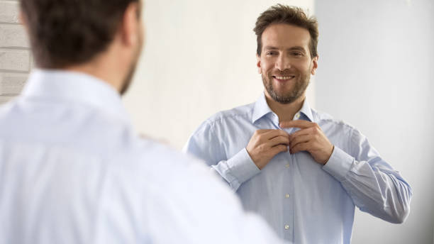 istock Confident male buttoning his shirt in optimistic mood, getting ready for work 1076951250