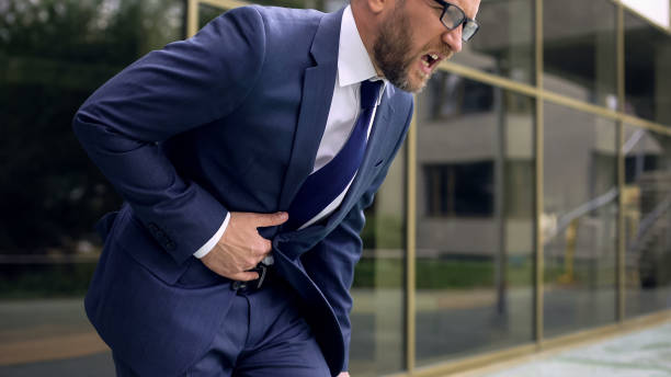 istock Worker in suit suffering from stomach ache, abdominal pain, gastroenteritis 1076953834