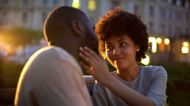 istock Young lady tenderly stroking boyfriends face, love expression, romantic date 1076954186