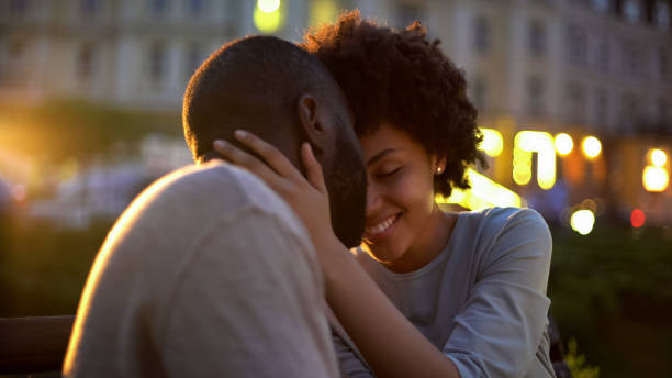Petty woman tenderly stroking boyfriends face, love expression, nuzzling on date Petty woman tenderly stroking boyfriends face, love expression, nuzzling on date date night romance stock pictures, royalty-free photos & images