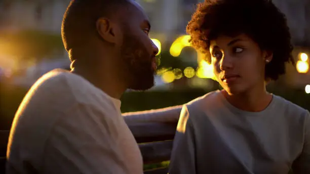 Woman looking at boyfriend with hope, outdoor date, misunderstanding, conflict