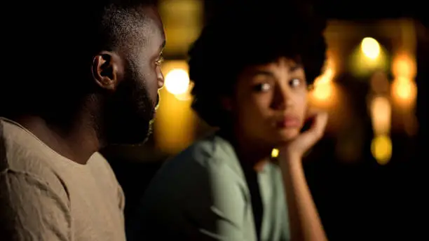 African male apologizing to girlfriend, arguing couple at night city, conflict