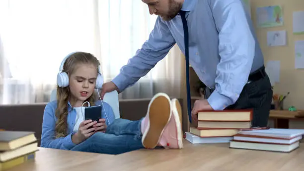 Single father trying to speak with daughter, listening to music and ignoring him